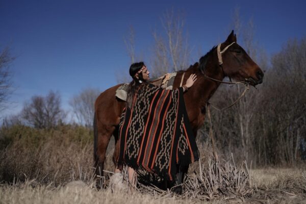Andrea Navarro (Fotografía luciendo Poncho de Guarda Atada “Familia Avar Saracho” de Jorge Pablo Sampo para Fondo Nacional de las Artes) La Carlota Pcia. de Córdoba