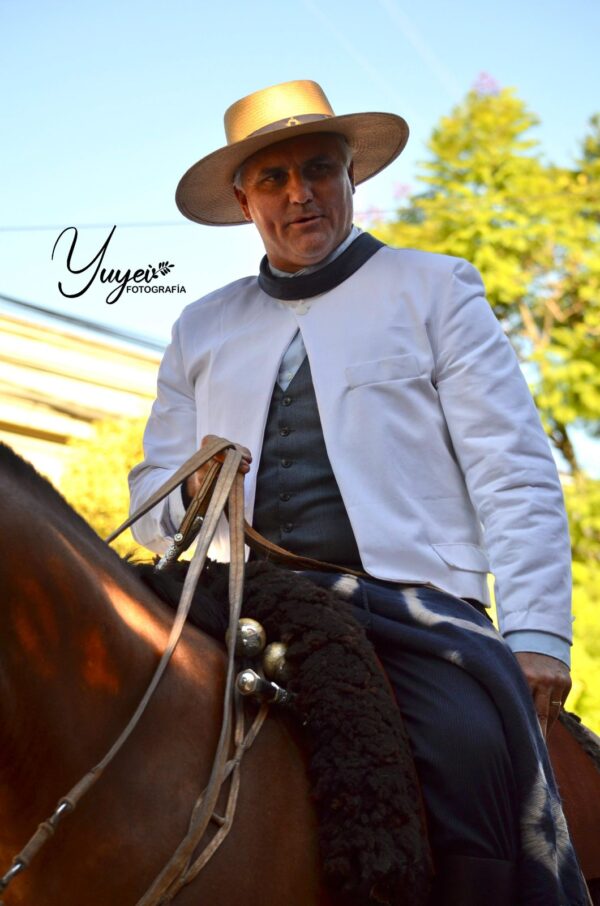 Facundo Cunningham en la Fiesta Provincial del Caballo Urdinarrain Entre Ríos (Poncho de Argollas “Familia Avar Saracho”) Baradero Pcia. de Buenos Aires  Poncho de Argollas, hilado manualmente en lana de oveja, tejido en telar criollo, teñido artesanal de las argollas utilizando la técnica de reserva llamada "plangit" (tie dye) que consiste en realizar ataduras sobre un tejido terminado. Al teñir el conjunto, las zonas atadas conservan el color original. Los círculos y rombos han sido los elementos de diseño más usados y siempre se los ha asociado a la piel moteada de felinos y serpientes y al alto valor simbólico de estos animales.